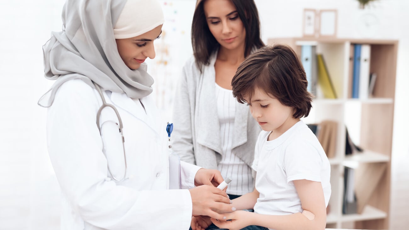 The Arab doctor examines the sick boy. He and his mother came to the hospital. Arabian hospital concept. Pediatrician office and sick child.; Shutterstock ID 1019519716