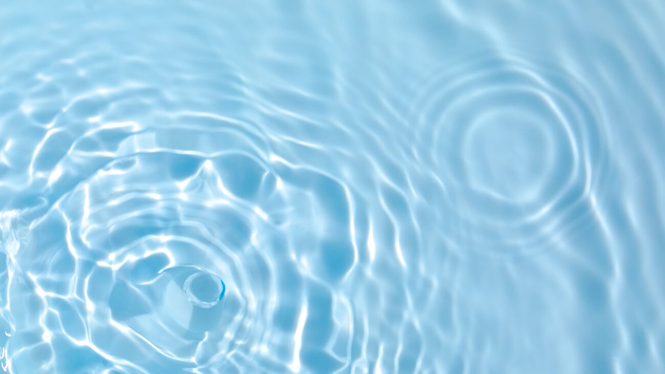 De-focused blurred transparent blue colored clear calm water surface texture with splashes and bubbles. Trendy abstract nature background. Water waves in sunlight with copy space.; Shutterstock ID 1893999334
