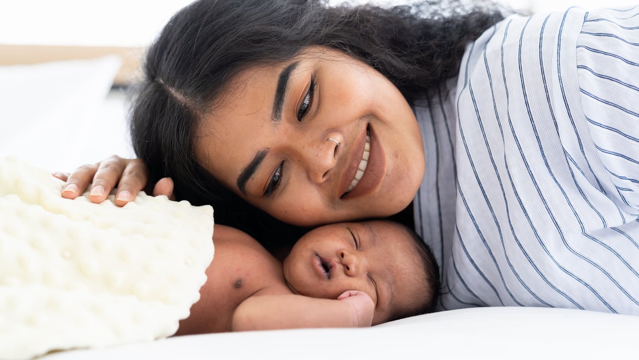 African American mum kissing her newborn baby on the bed. Closeup of infant with mother. Woman and adorable little African American baby on bed ; Shutterstock ID 1921499663