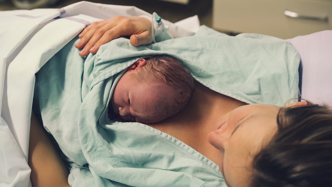 Mother and newborn. Child birth in maternity hospital. Young mom hugging her newborn baby after delivery. Woman giving birth. First moments of baby life after labor.; Shutterstock ID 1938100300