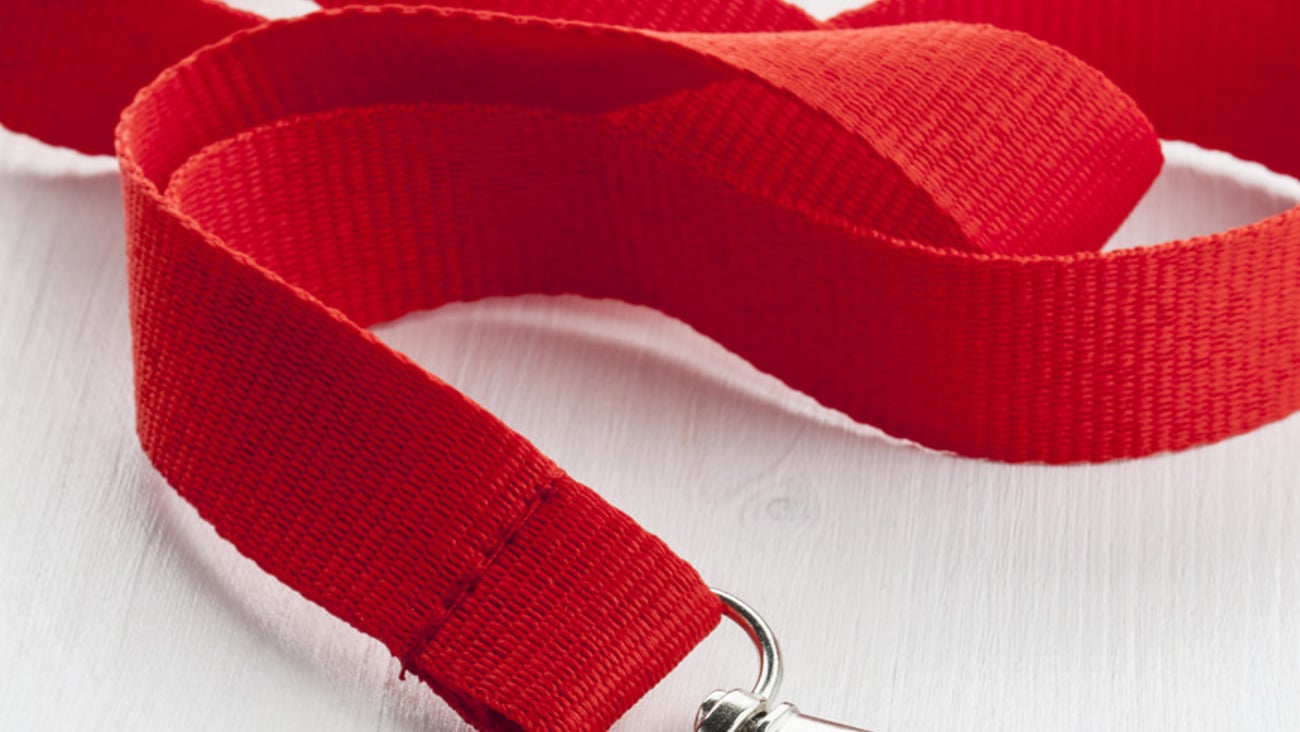 Red lanyard with metal carabiner on the white wooden table.; Shutterstock ID 217962340