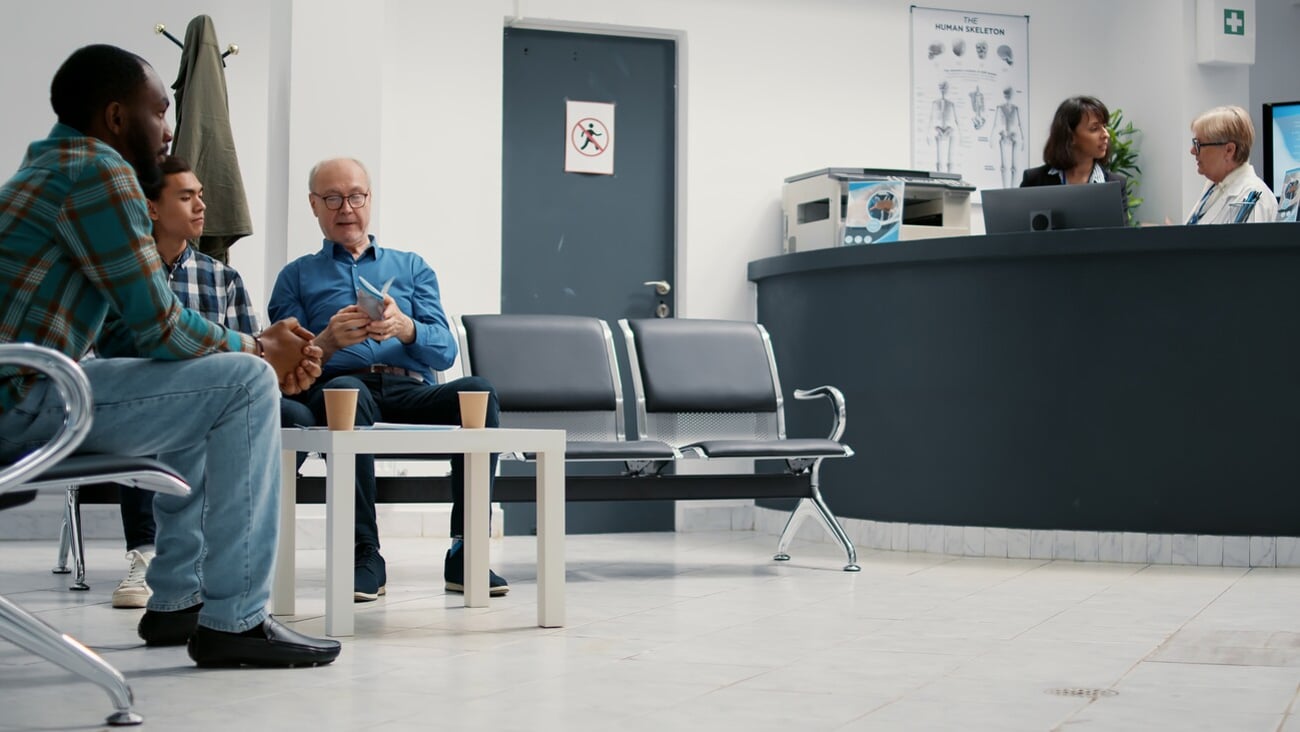 Mother with little girl leaving waiting room lobby to attend consultation and diverse group of people sitting in row. Examination support for medical checkup visit with registration. Tripod shot.; Shutterstock ID 2185665815