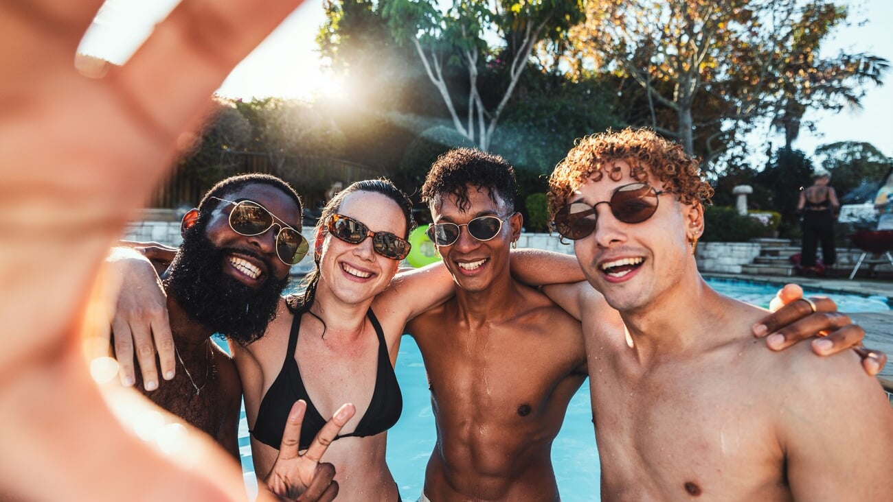 Peace sign, friends selfie and pool party, having fun or partying on new year. Swimming celebration, water event and group portrait of people with hand gesture, laughing and taking social media photo; Shutterstock ID 2254314255