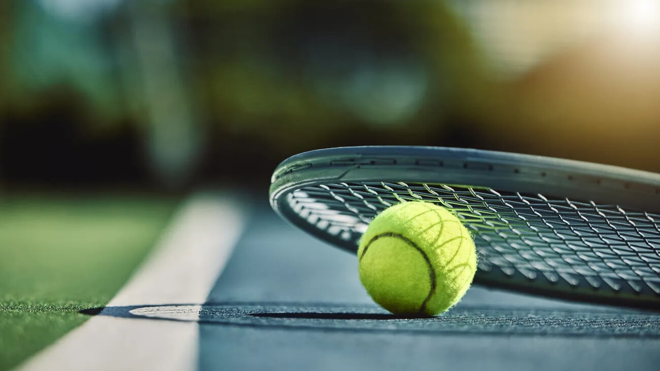 Tennis ball, racket and court ground with mockup space, blurred background or outdoor sunshine. Summer, sports equipment and mock up for training, fitness and exercise at game, contest or competition; Shutterstock ID 2260931705