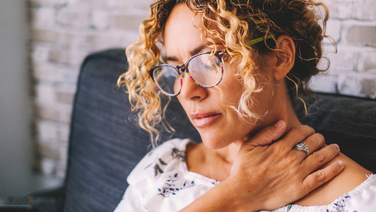 Sick middle age adult young women touching the neck have shoulder and neck pain.Healthcare and medicine concept. Female people suffering shoulder disease at home sitting on the sofa; Shutterstock ID 2264262333