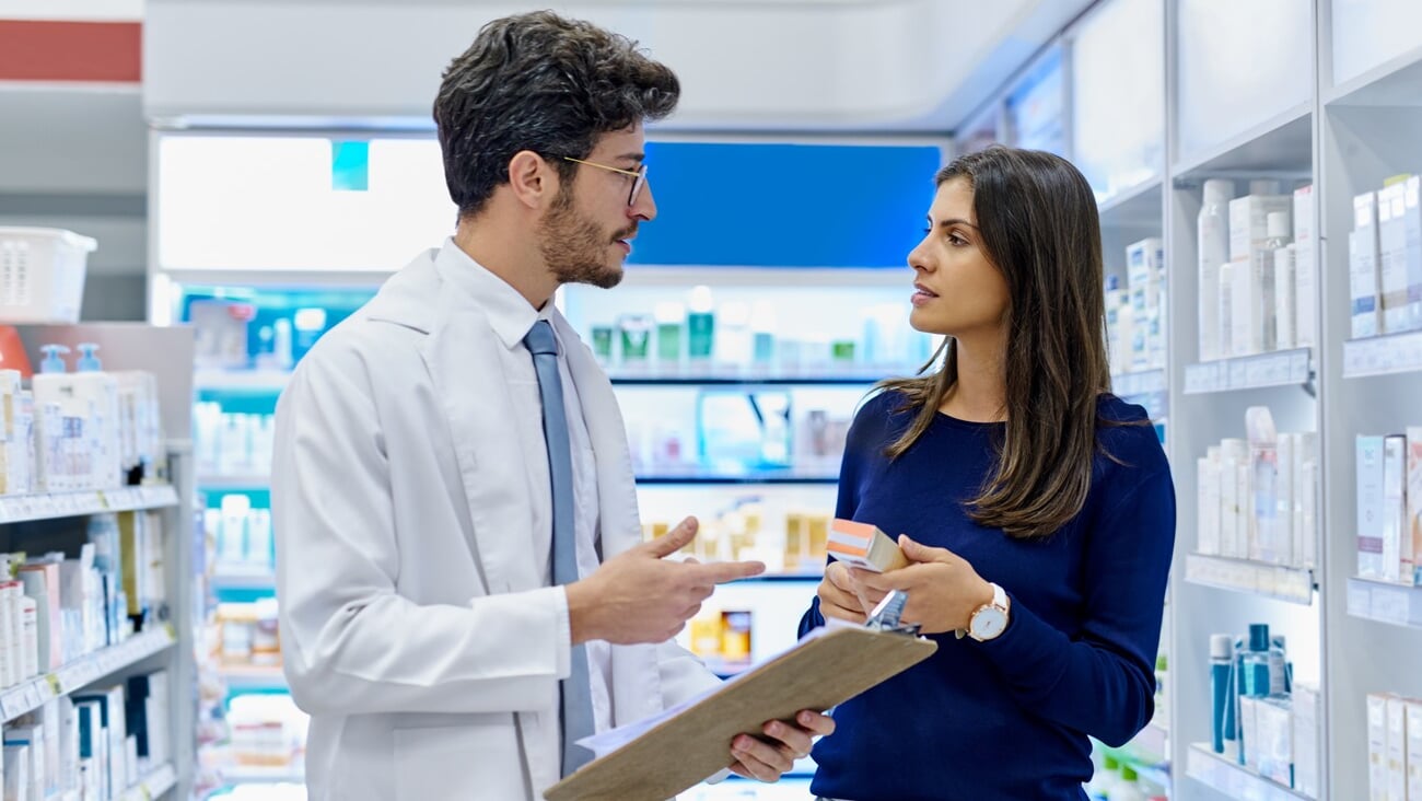Pharmacy, medicine and pharmacist talking to customer while working in a retail store. Professional man in pharmaceutical or medical industry for service, healthcare and advice for a woman client; Shutterstock ID 2315198817