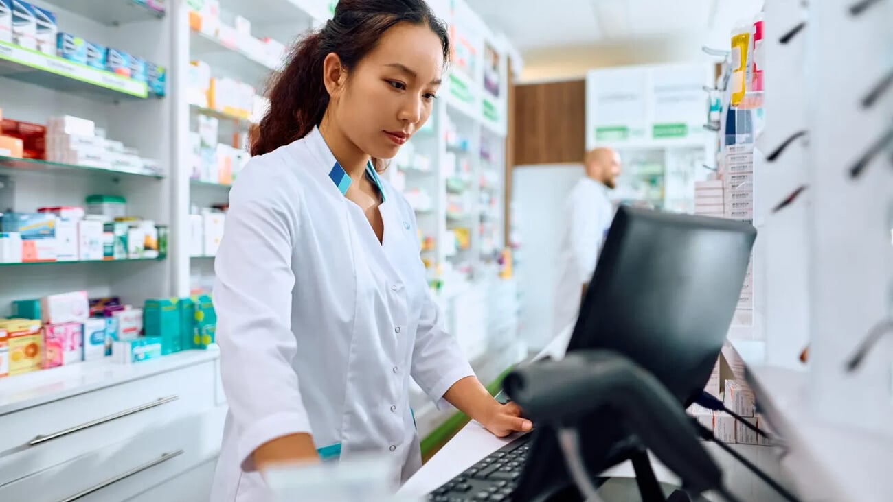 Female Chinese pharmacist using computer while working in a pharmacy. ; Shutterstock ID 2320079431