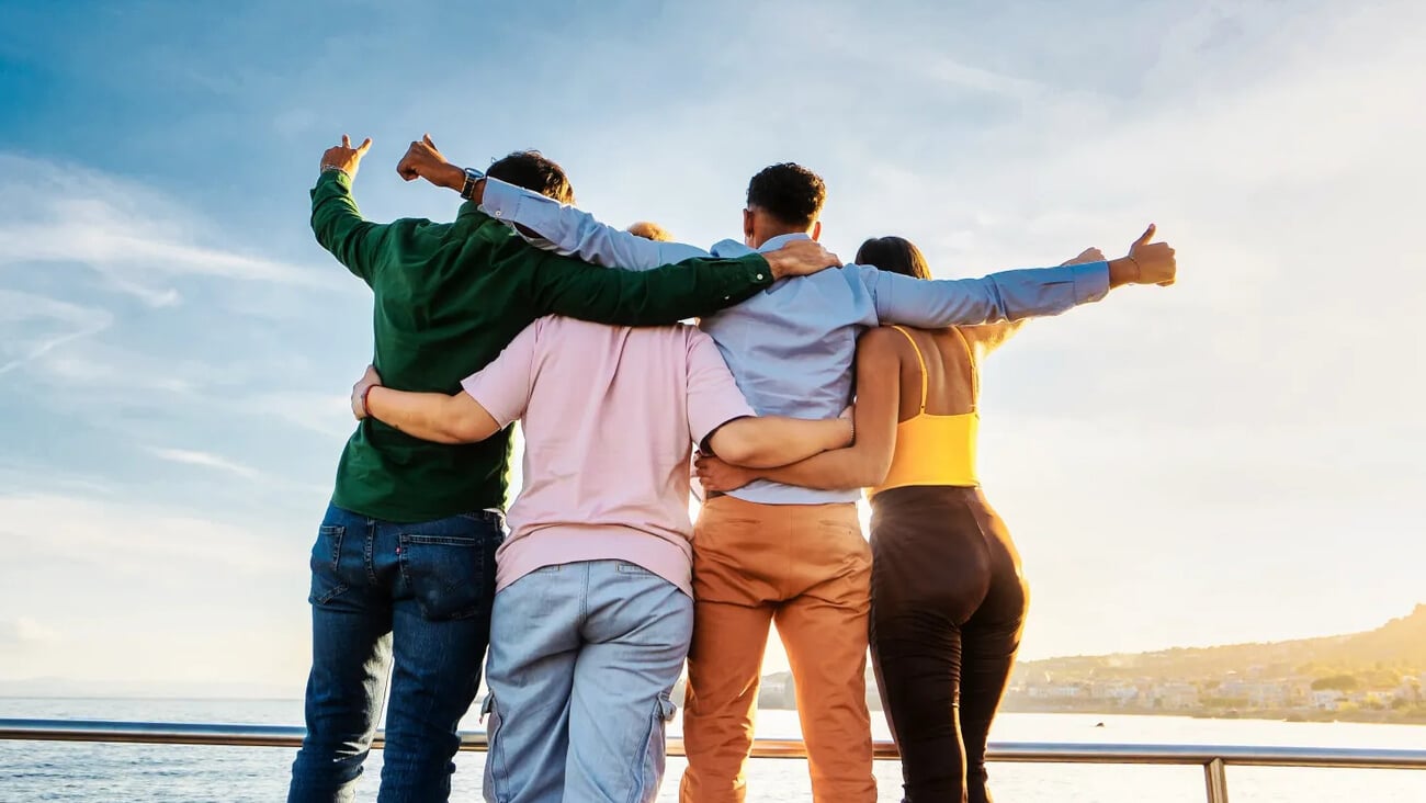 Diverse Friends Embracing at Sunset - Four friends of diverse ethnicities, seen from behind, embrace and face the setting sun.; Shutterstock ID 2336118719