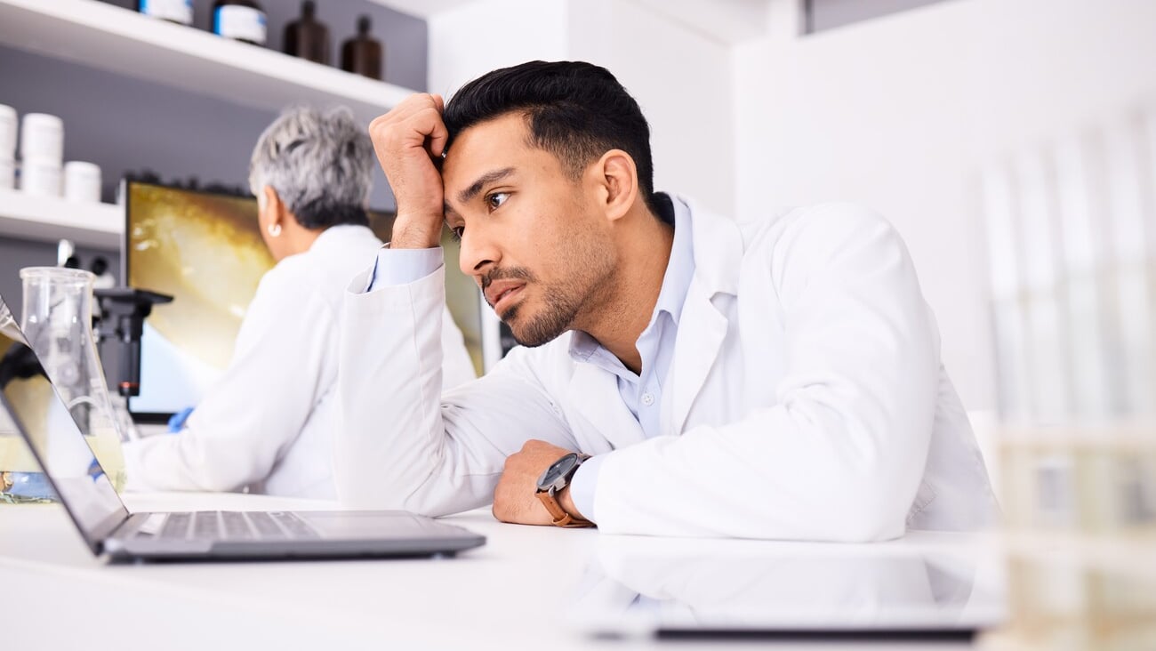 Scientist, stress and headache for computer research, planning and data analysis, mistake or healthcare results. Sad or tired science man or doctor working on laptop in medical or medicine laboratory; Shutterstock ID 2360731375