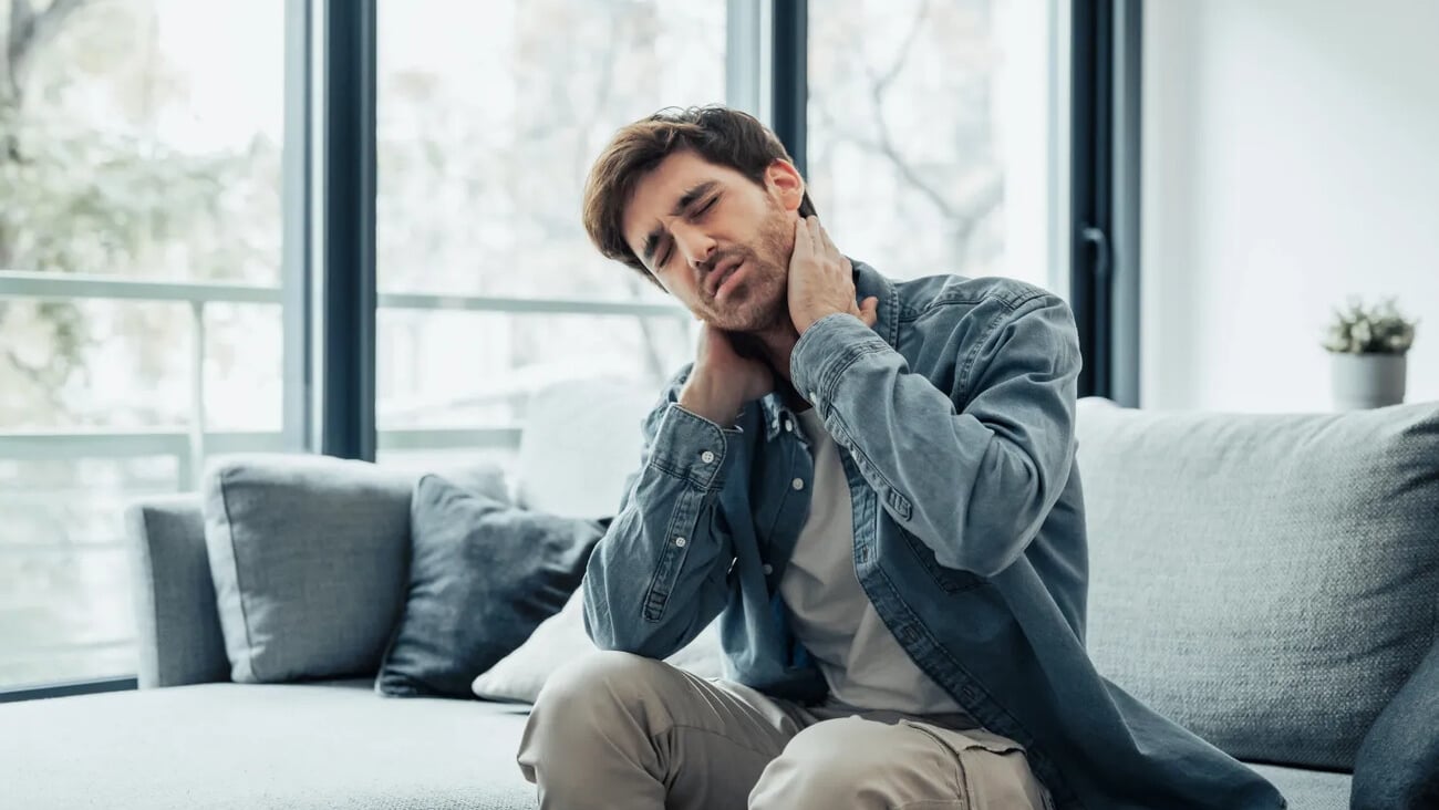 Upset tired young man feeling pain massaging stiff neck rubbing tensed muscles to relieve back ache joint shoulder discomfort after long sedentary work in incorrect posture, fibromyalgia concept; Shutterstock ID 2473263351
