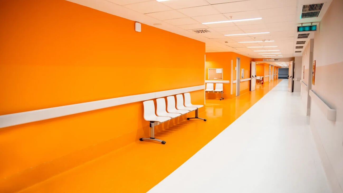Empty modern hospital corridor, clinic hallway interior background with white chairs and yellow wall; Shutterstock ID 2520097193