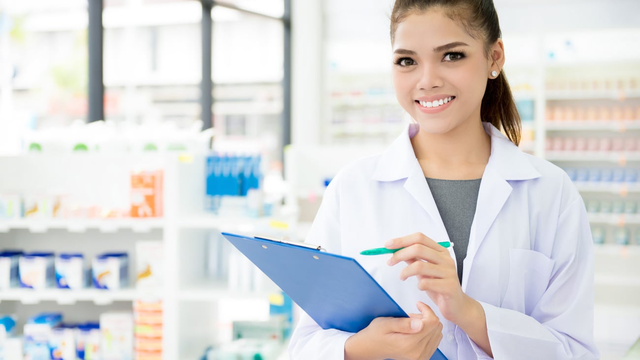 Smiling Asian female pharmacist working in chemist shop or pharmacy; Shutterstock ID 679521298