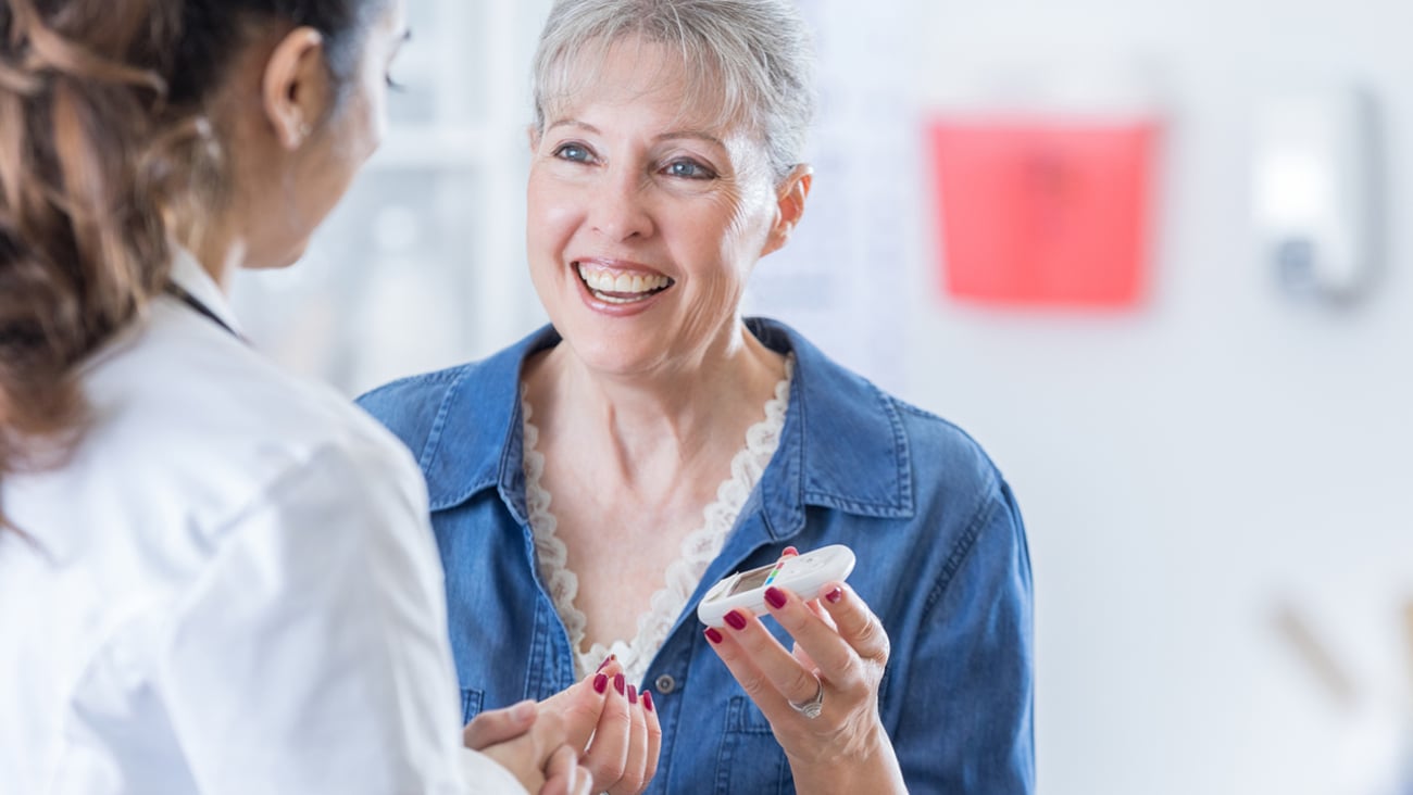 Middle aged white woman smiling having a discussion with her pharmacist