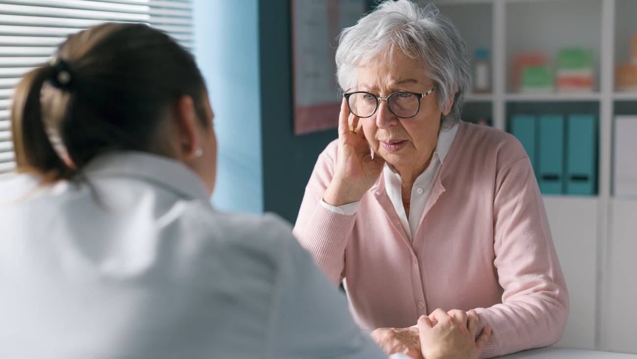 Elderly female patient talking to doctor