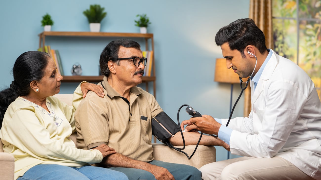 couple with male having blood pressure taken by male doctor