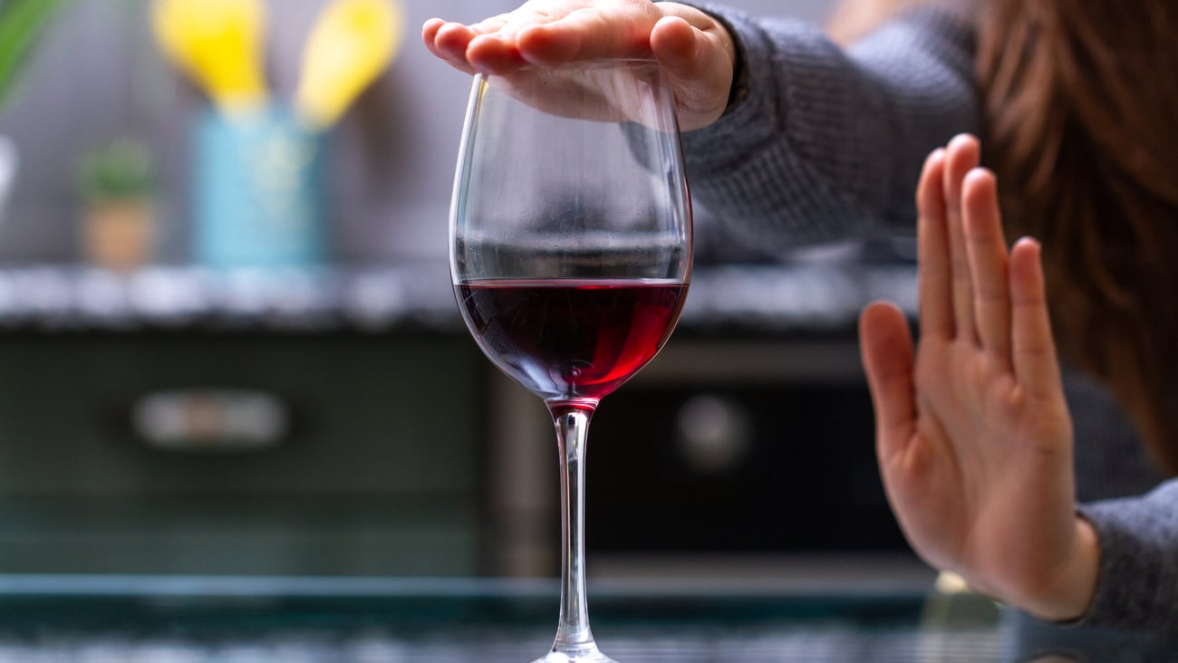 Woman refusing a glass of red wine