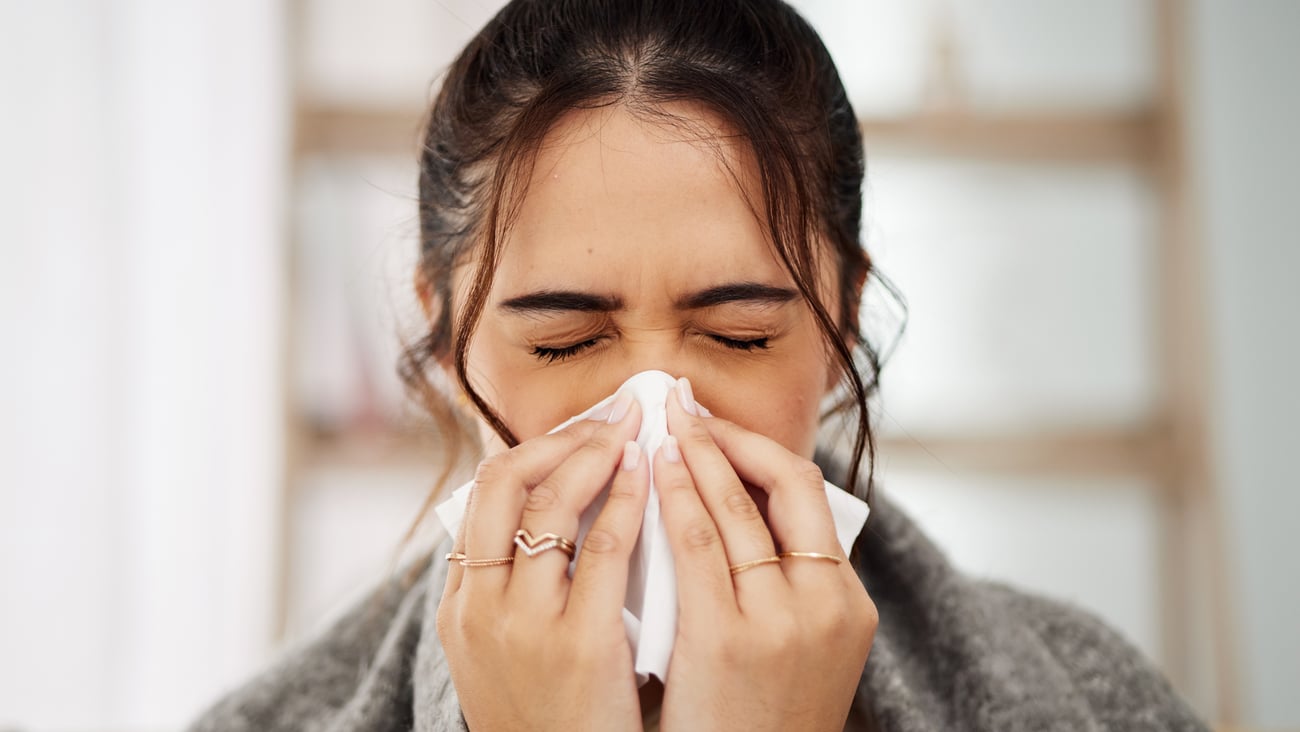 Young woman covering her nose with a tissue