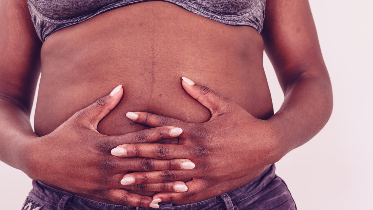 Close up of Black woman holding her hands over her belly