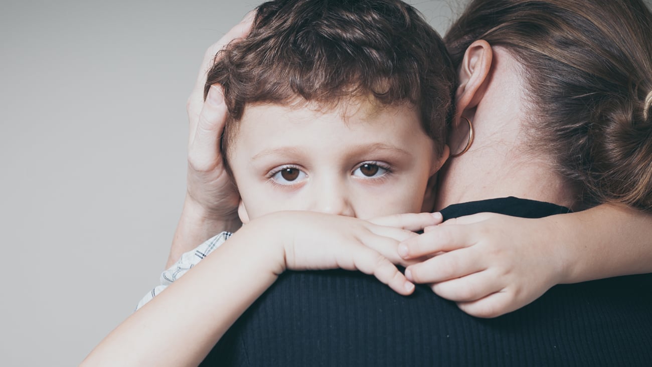 Young boy being held by a parent