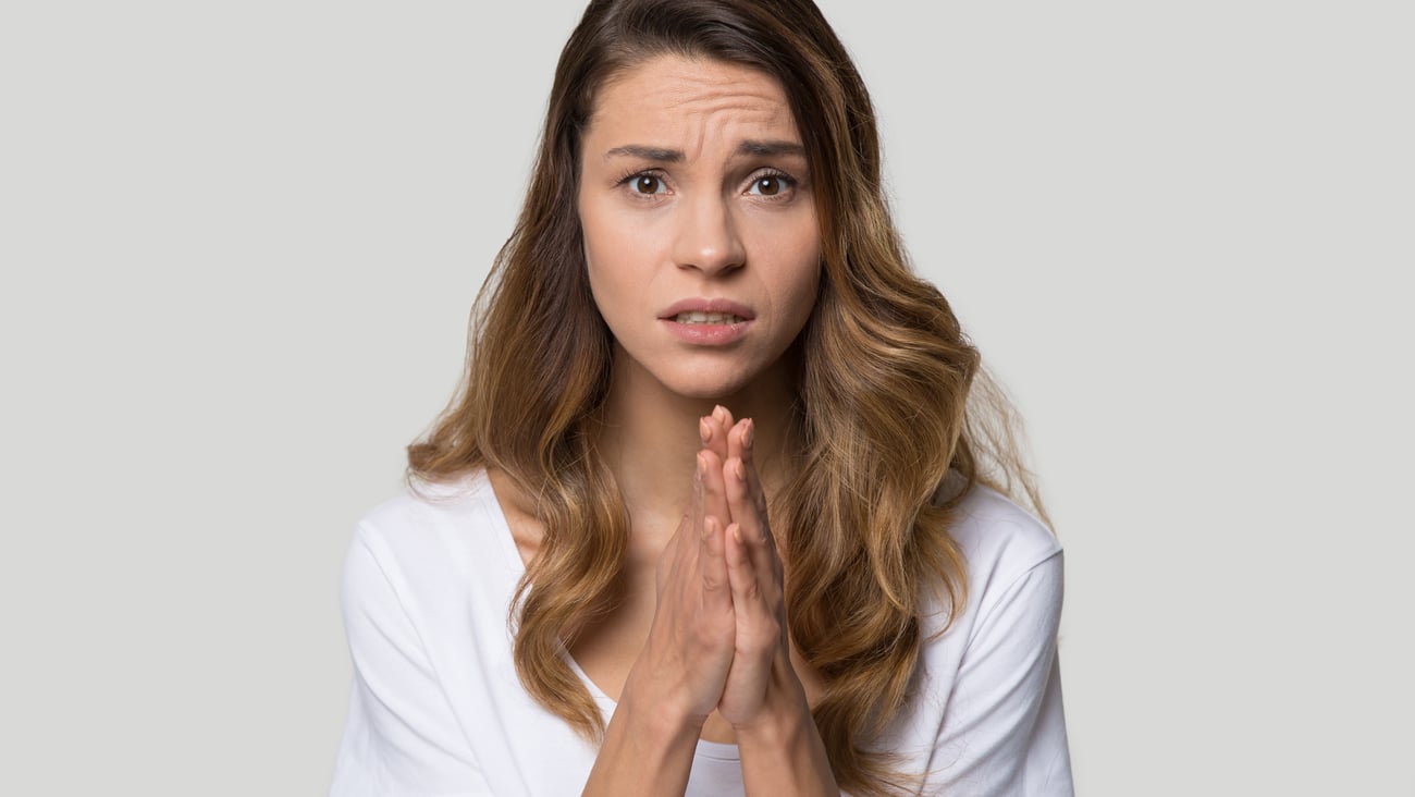 Young white woman asking for favour with hands in prayer position