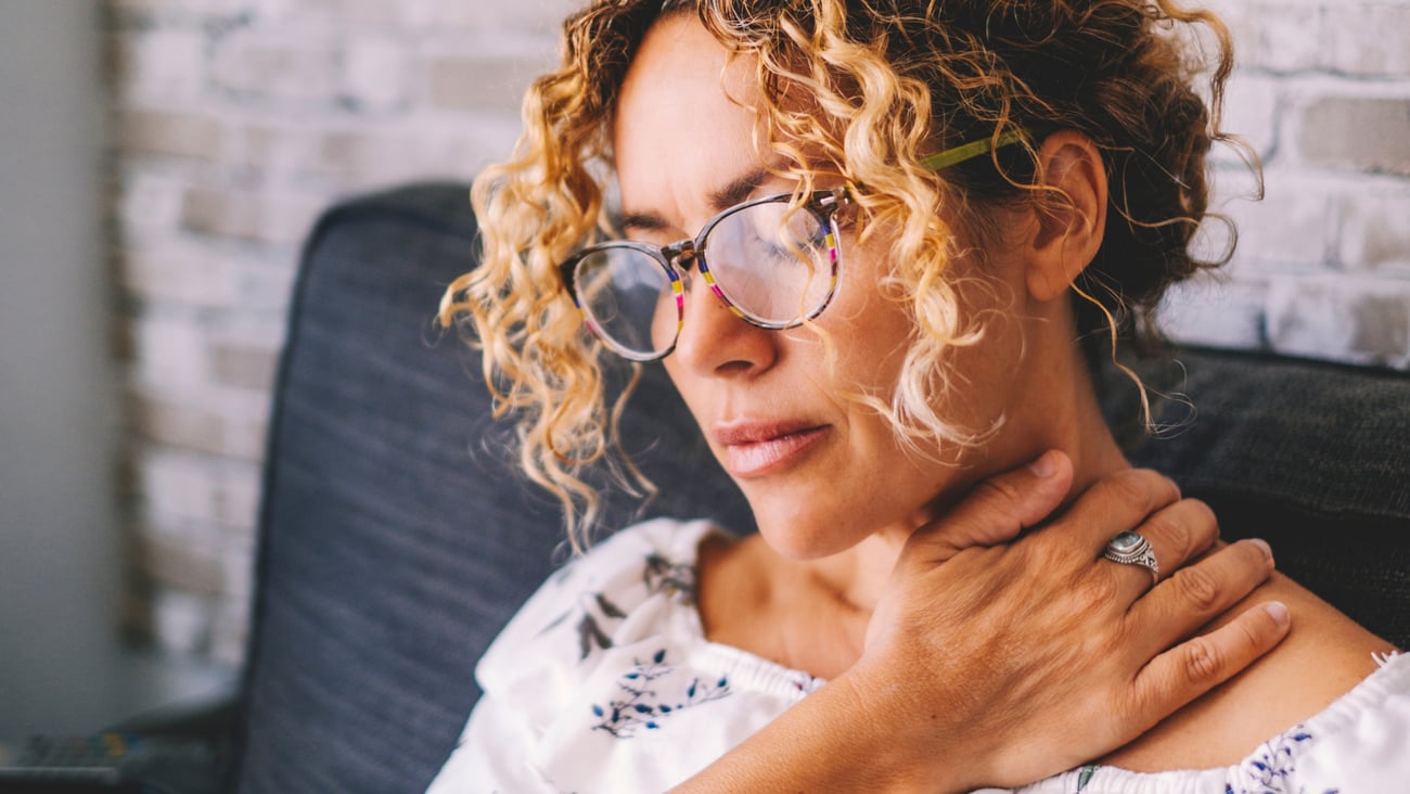 Middle-aged woman holding her neck from fibromyalgia pain