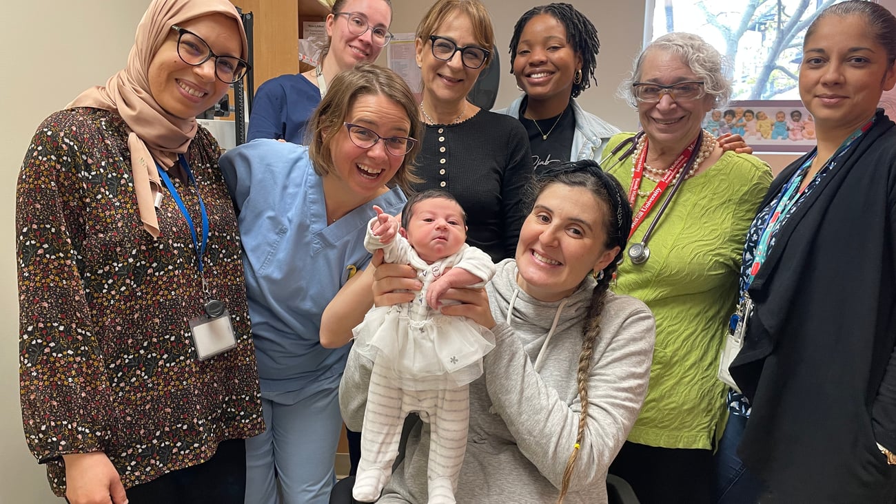 A group of healthcare workers posing around a new baby