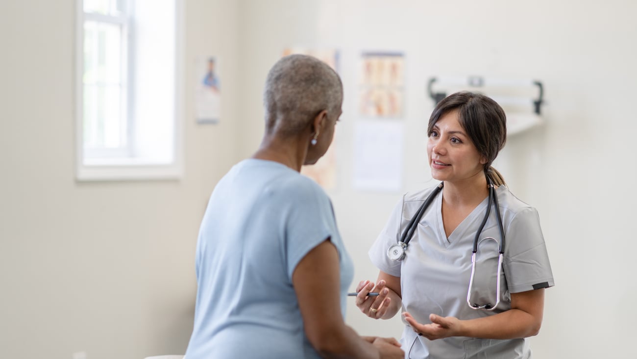 Doctor speaking to middle-aged woman experiencing menopause