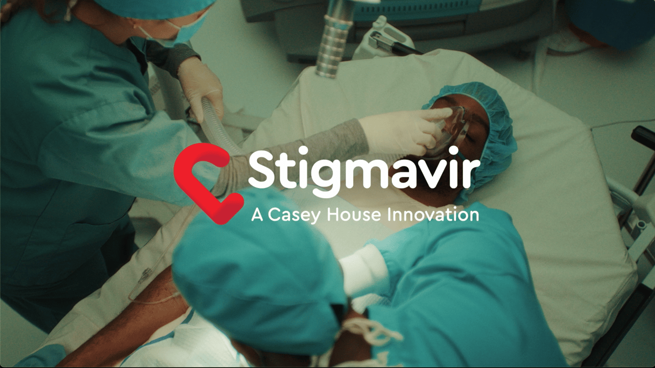 The words Stigmavir on top of a doctor holding a mask on an unconscious patient