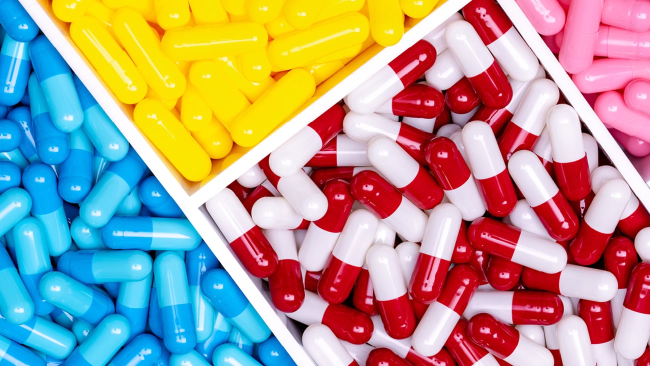 Overhead view of separated trays of different-coloured pills