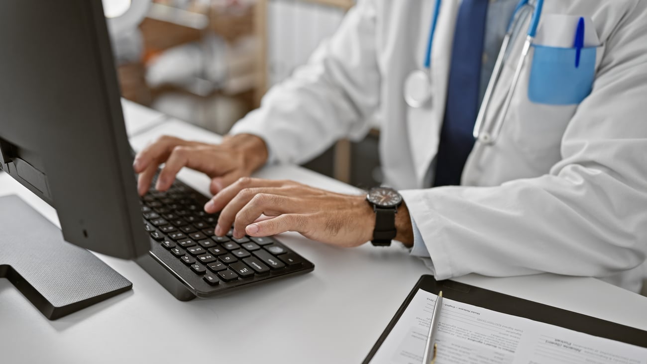 A doctor using a computer working at the clinic