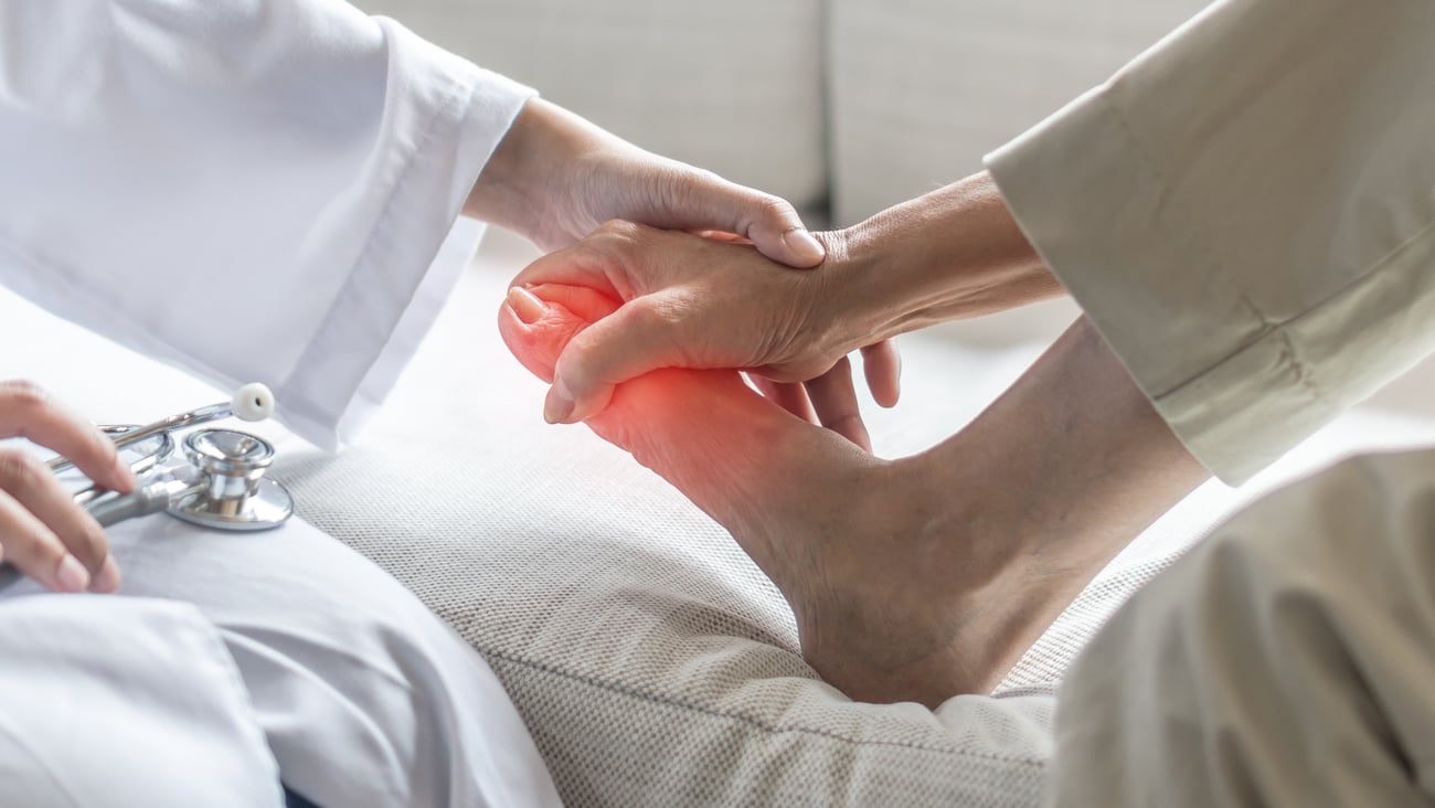 Doctor examining patient holding foot in pain