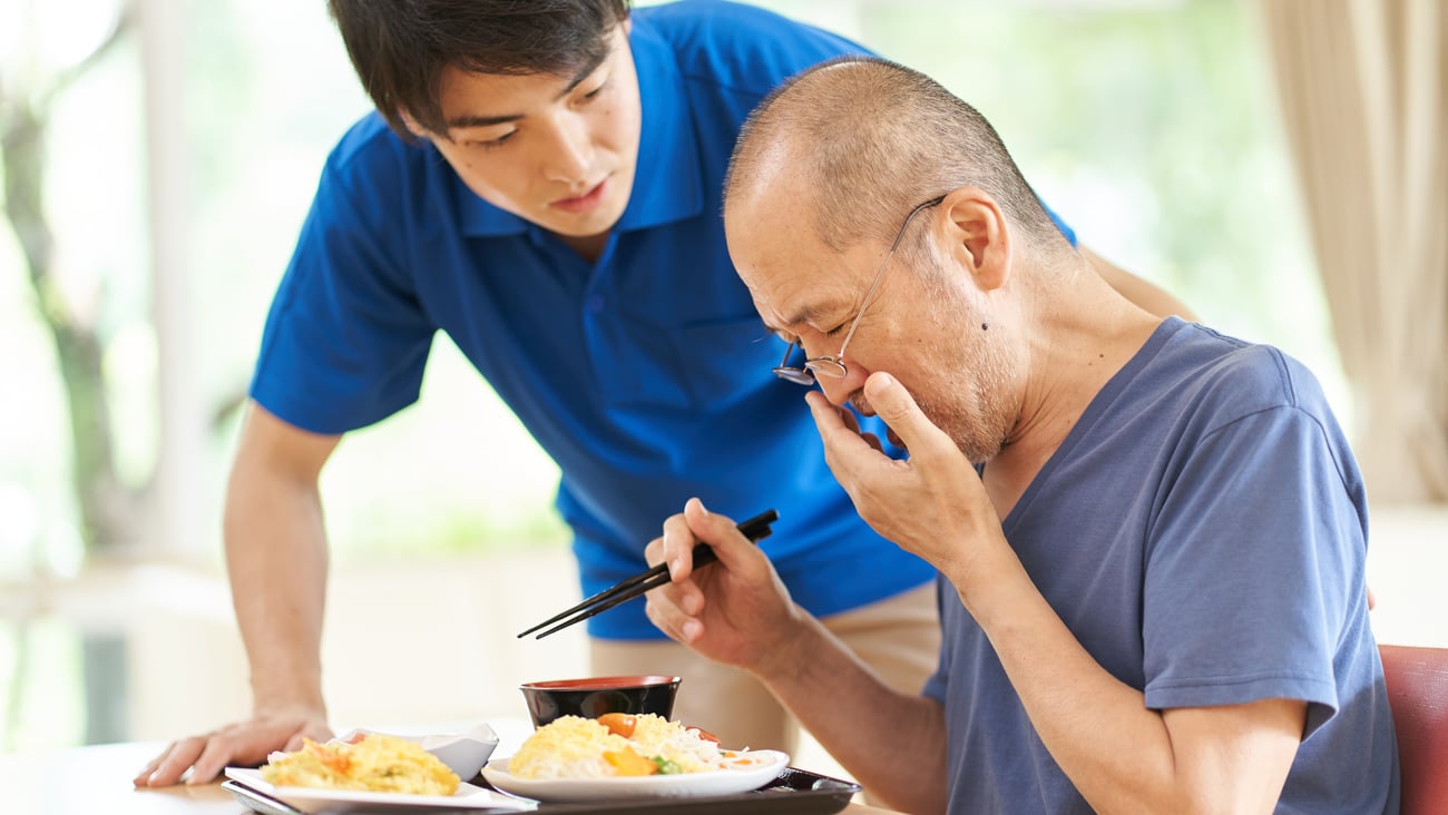 Older asian man choking on food