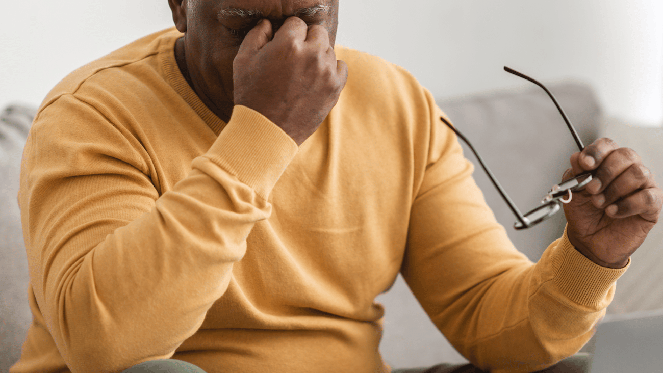 Older black man rubbing his eyes