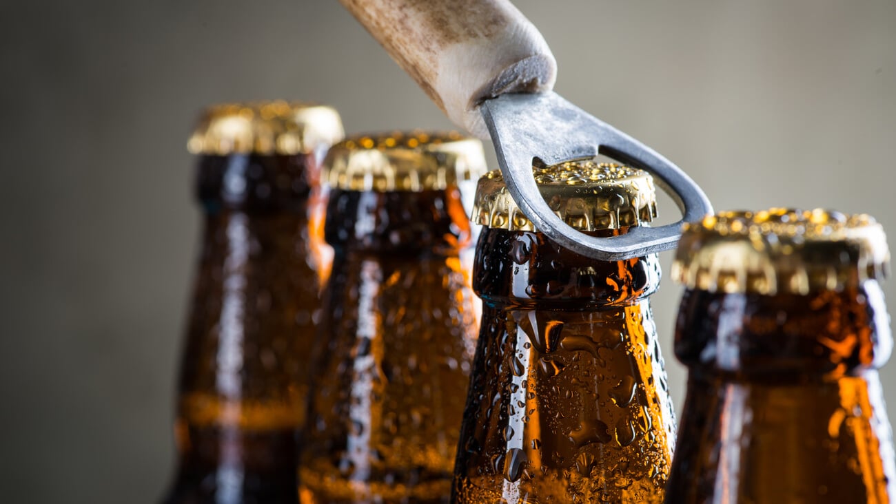 Brown ice cold beer bottles with water drops and old opener; Shutterstock ID 290775062