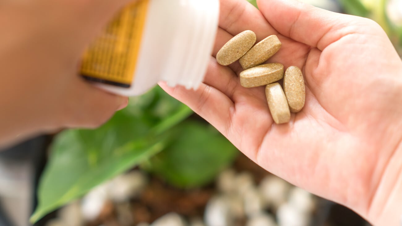 Top view of alternative organic medicine or herbal viatmin supplement capsule tablet on woman hand with copyspace background. Concept of healthy eating lifestyle.; Shutterstock ID 1913786272