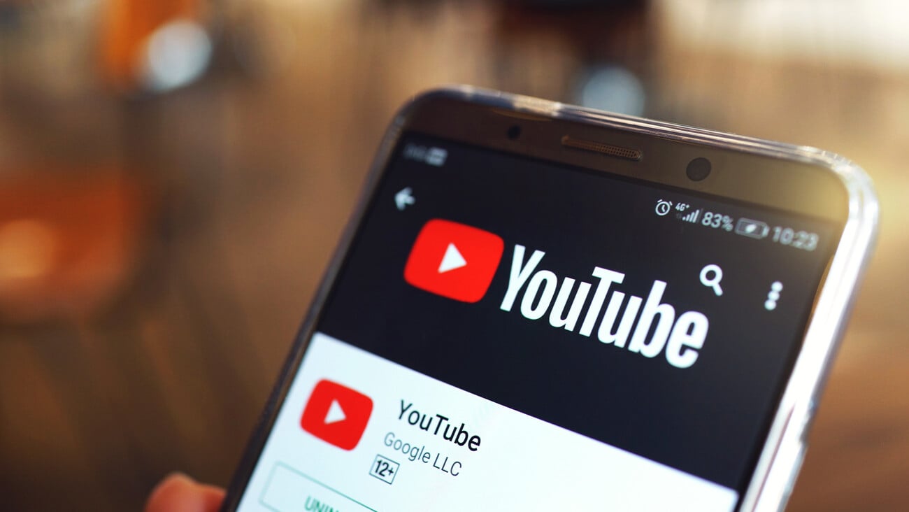 Penang, Malaysia - April 6, 2018: Woman holding a smartphone with social Internet service Youtube on the screen. Blurred cafe interior on a background.; Shutterstock ID 1064473979