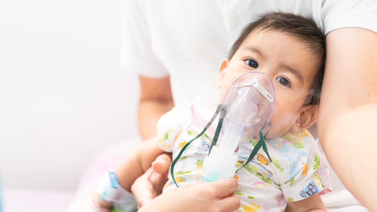 Close up of asian little baby boy is treated respiratory problem with vapor nebulizer to relief cough symptom in the hospital room , concept of pediatric patient care for sick in the hospital.; Shutterstock ID 1589743531