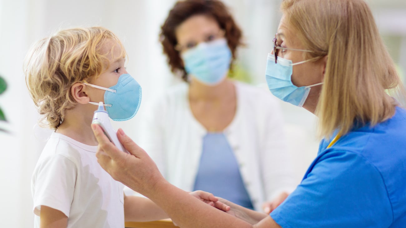 Pediatrician doctor examining sick child in face mask. Ill boy in health clinic for test and screening. Kids home treatment of virus. Coronavirus pandemic. Covid-19 outbreak. Patient coughing.; Shutterstock ID 1718116297