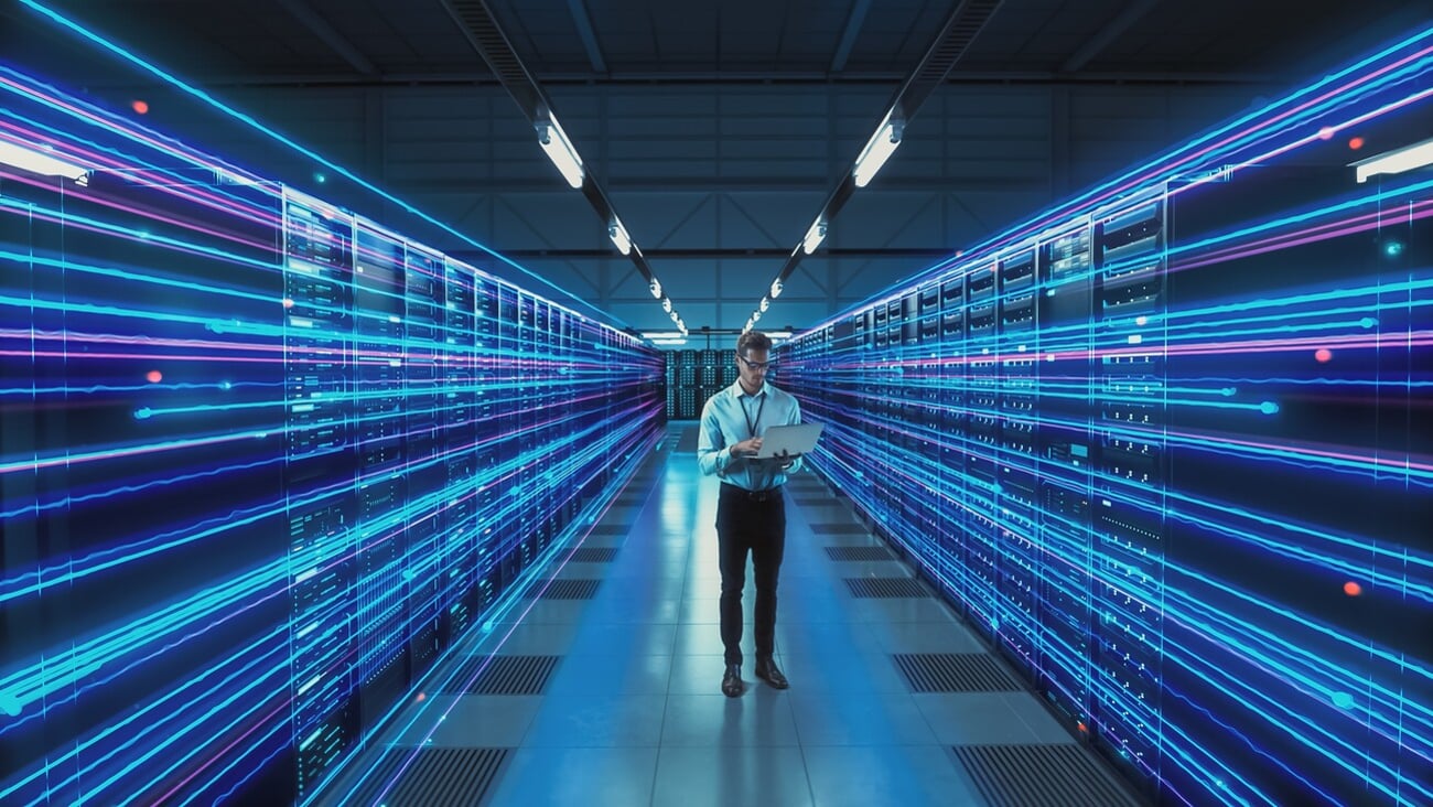 Futuristic Concept: Data Center Chief Technology Officer Holding Laptop, Standing In Warehouse, Information Digitalization Lines Streaming Through Servers. SAAS, Cloud Storage, Online Service; Shutterstock ID 2200880615