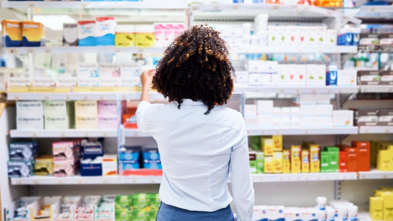 Back, pharmacy and medication with a woman customer buying medicine from a shelf in a dispensary. Healthcare, medical or treatment with a female consumer searching for a health product in a drugstore; Shutterstock ID 2304125557