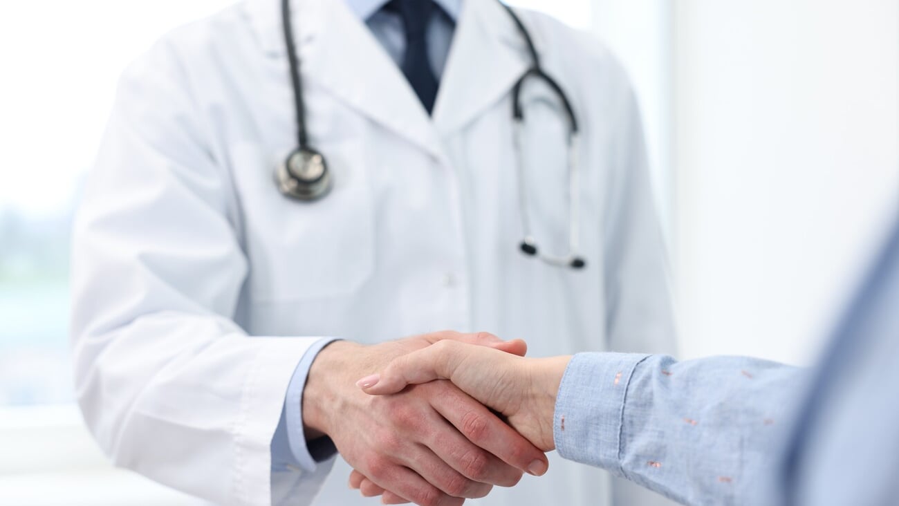 Doctor shaking hands with patient in clinic, closeup; Shutterstock ID 2490137287