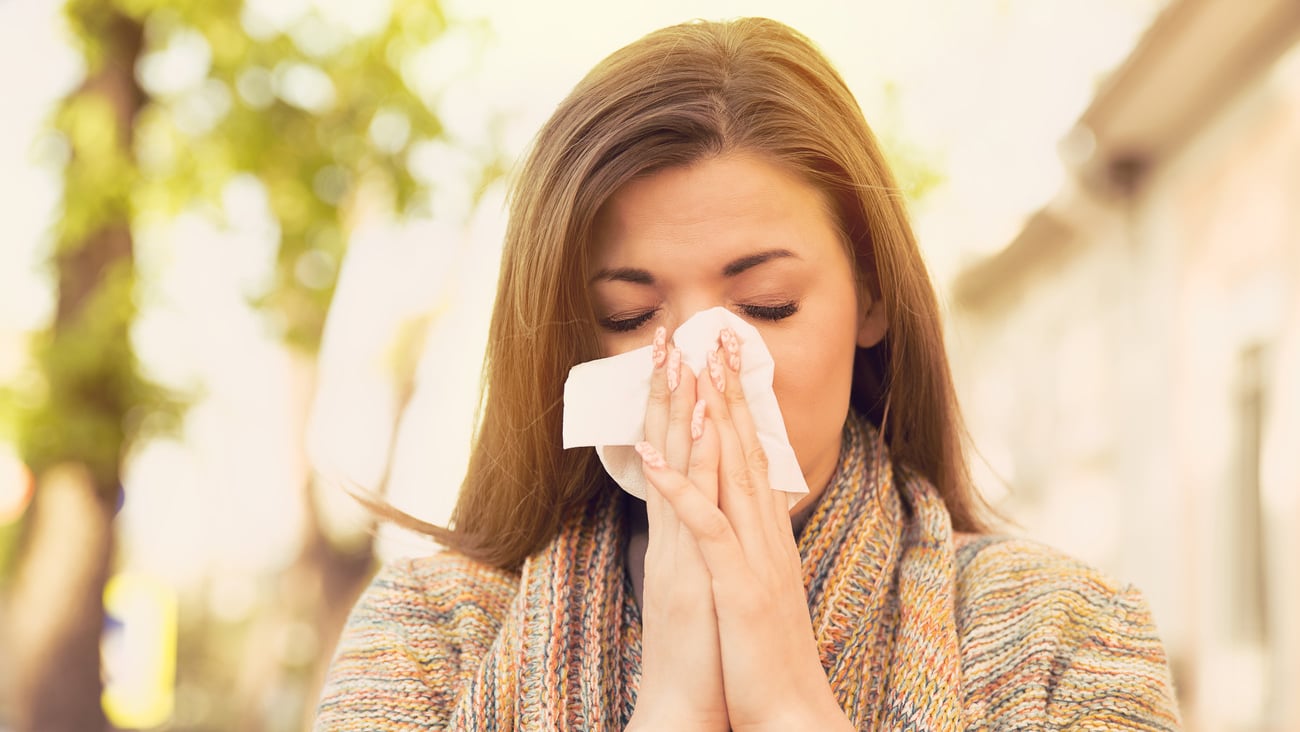 Woman with allergy symptoms blowing nose; Shutterstock ID 670193734