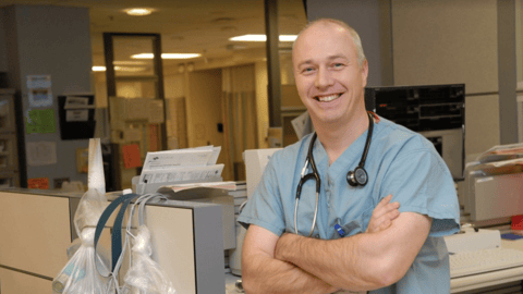 An emergency room doctor smiling for a picture in a hospital