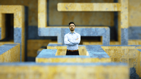 Man standing in the middle of a large, concrete maze