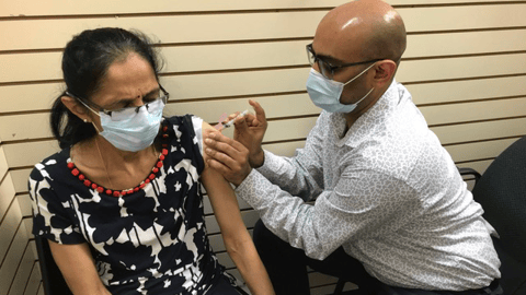 Pharmacy tech Jatan Patel vaccinates his mother.