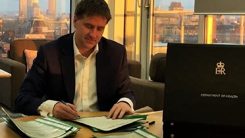 Steve Brine sitting at a table using a laptop