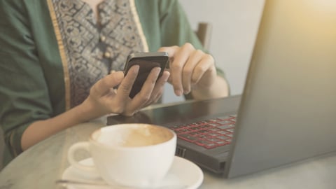 a person sitting at a table with a cup of coffee