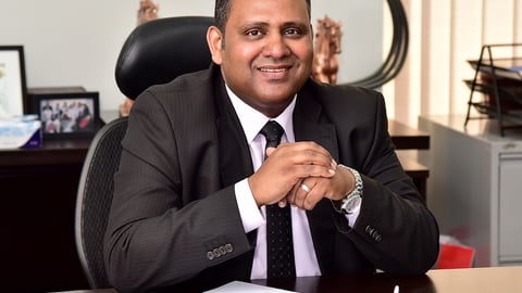 a man wearing a suit and tie sitting at a table