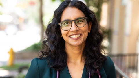 a person wearing glasses and smiling at the camera