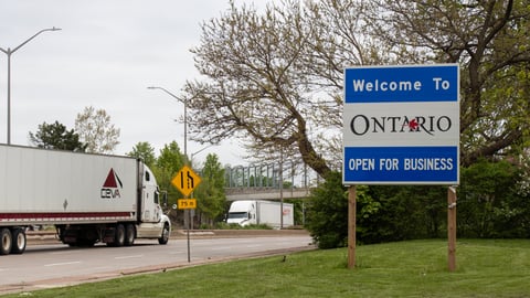 a truck that has a sign on the side of a road